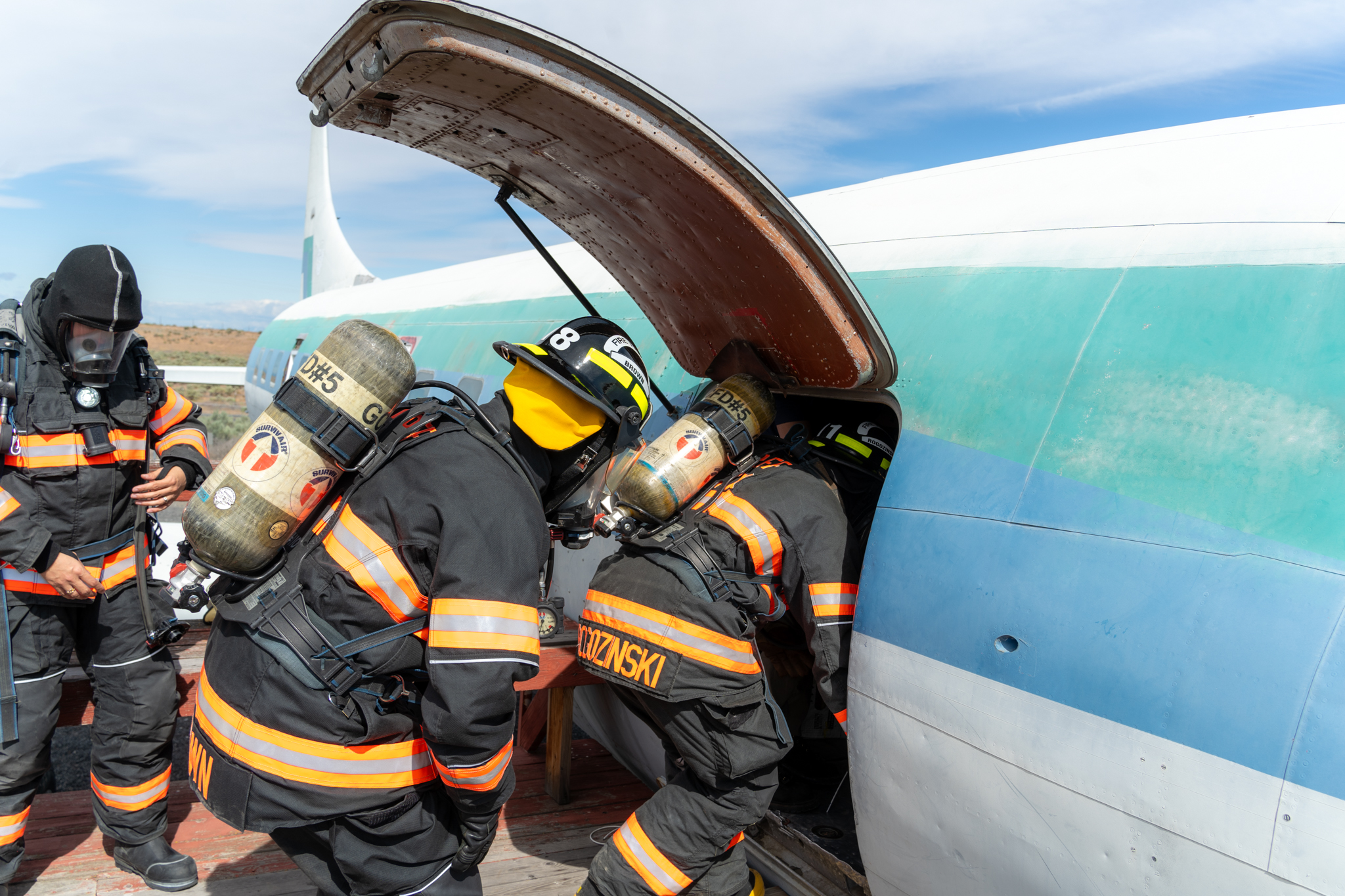 Firefighters entering into an airplane