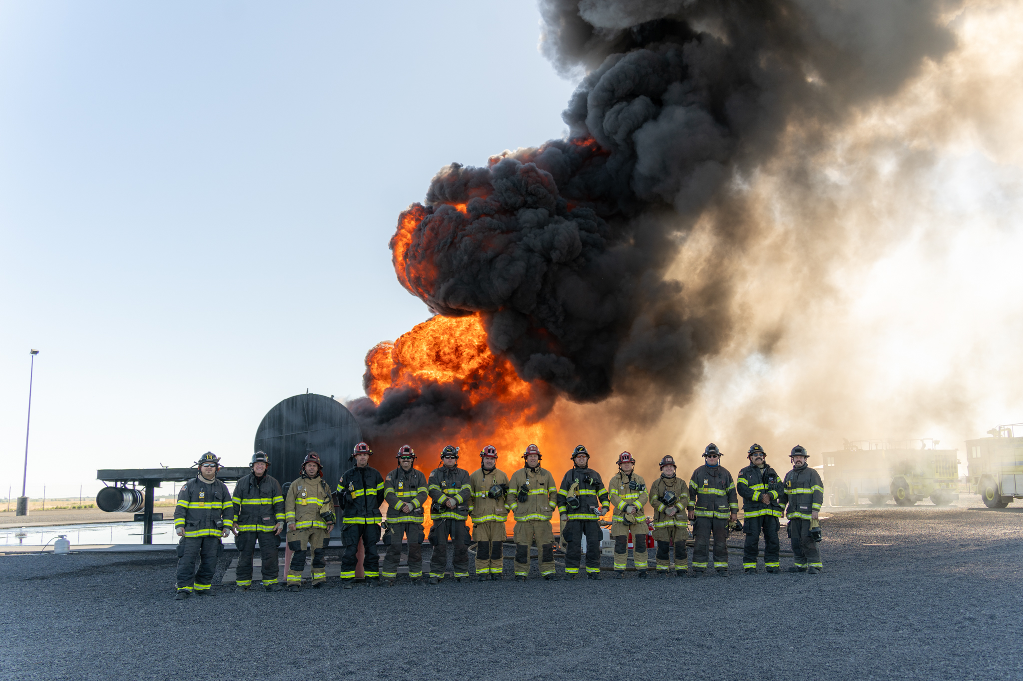 group of firefighters in front of burning airplane during training
