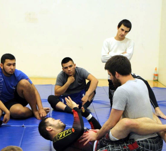 Jiu-Jitsu club members rolling on mats