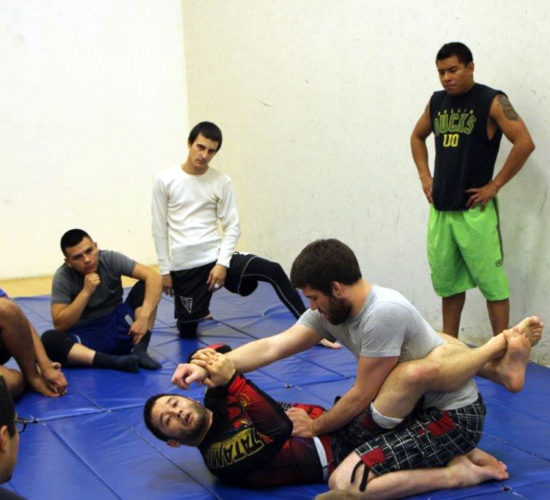 Jiu-Jitsu club members rolling on mats