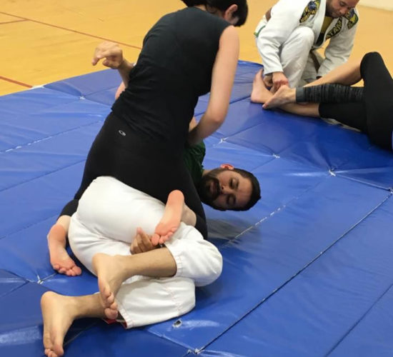 Jiu-Jitsu club members rolling on mats