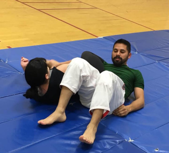 Jiu-Jitsu club members rolling on mats