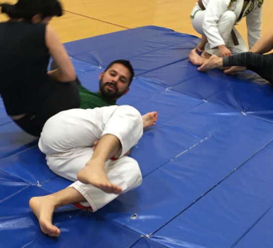 Jiu-Jitsu club members rolling on mats