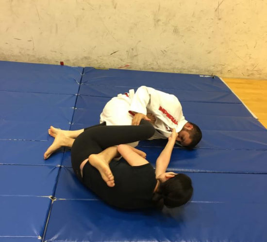 Jiu-Jitsu club members rolling on mats