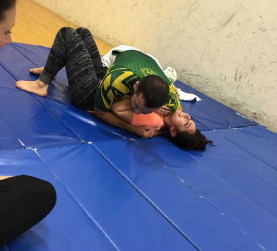 Jiu-Jitsu club members rolling on mats