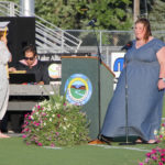 student singing the national anthem at graduation