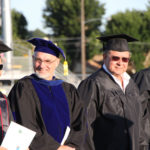 board member and faculty waiting to walk in