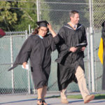 two faculty walking entering the field for ceremony