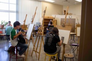 students at easel in art classroom