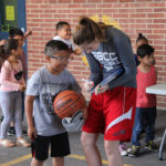 female athlete signing a book for a boy at elementary school
