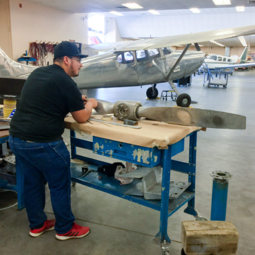 Student working by airplane