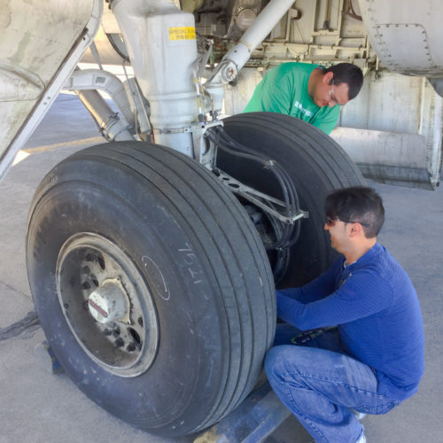 Students working on airplane landing gear