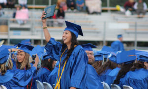 a girl at graduation showing her diploma 