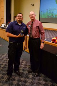 Male employee receiving award from college president