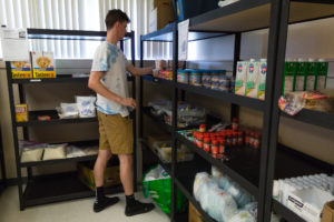 student standing by food pantry shelves