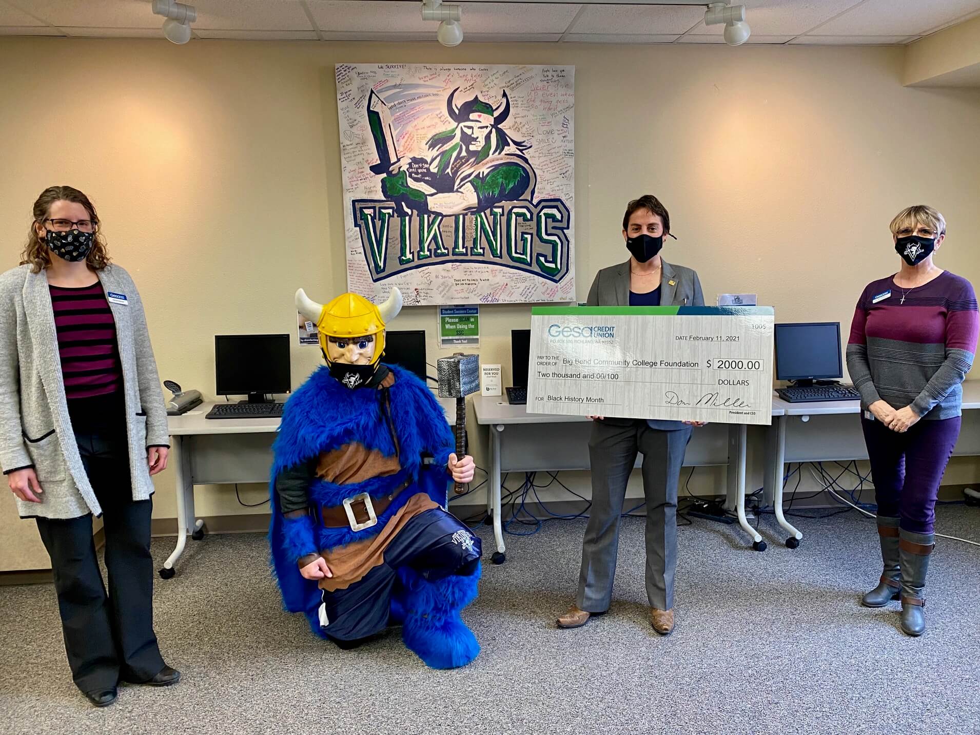 BBCC president Dr. Sara Thompson Tweedy holds giant check and stands with Thor the mascot