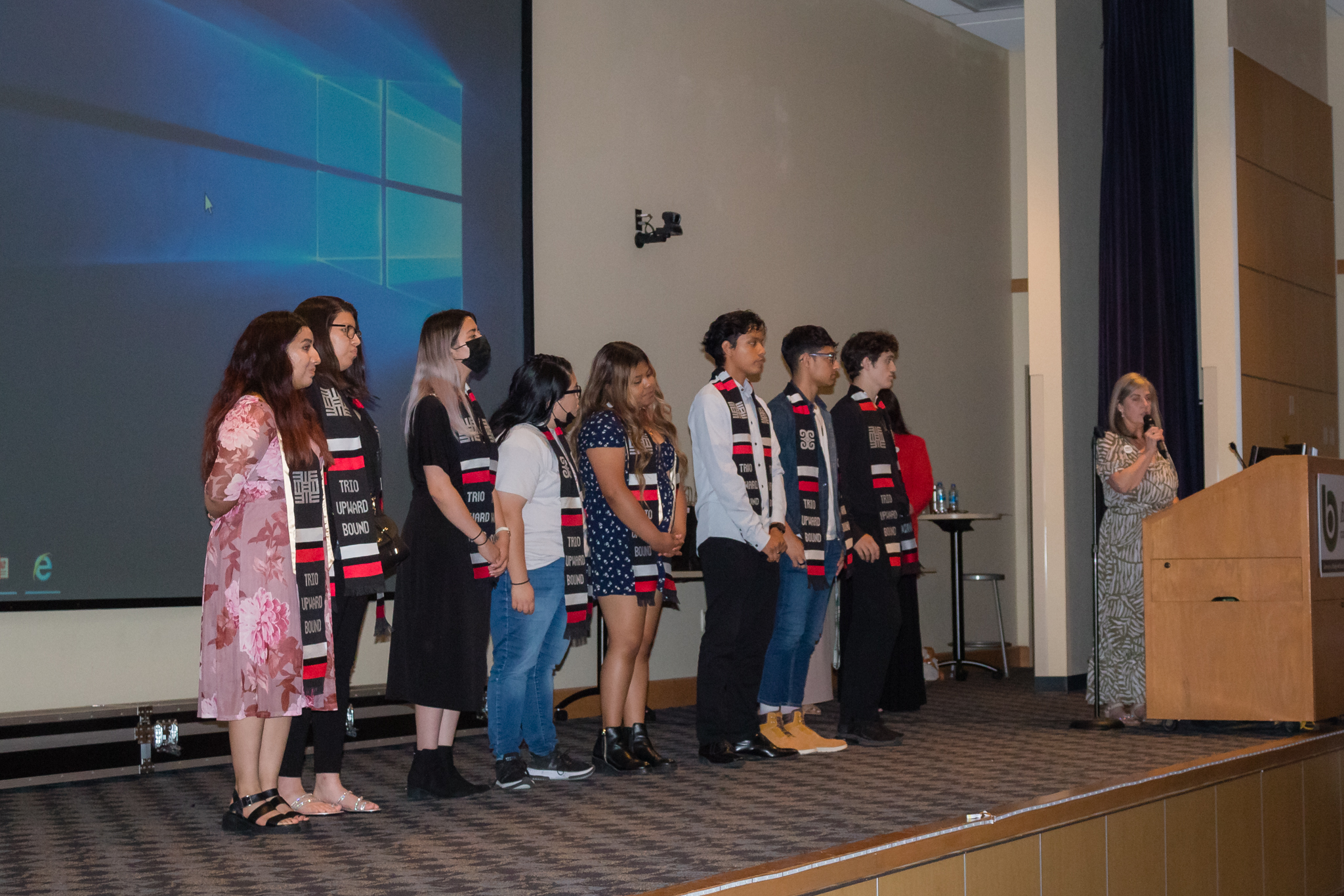 trio staff hand out awards to group of students on stage