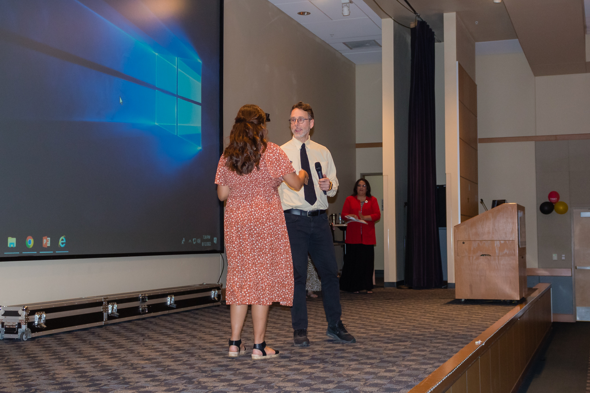 instructor hands award to female student