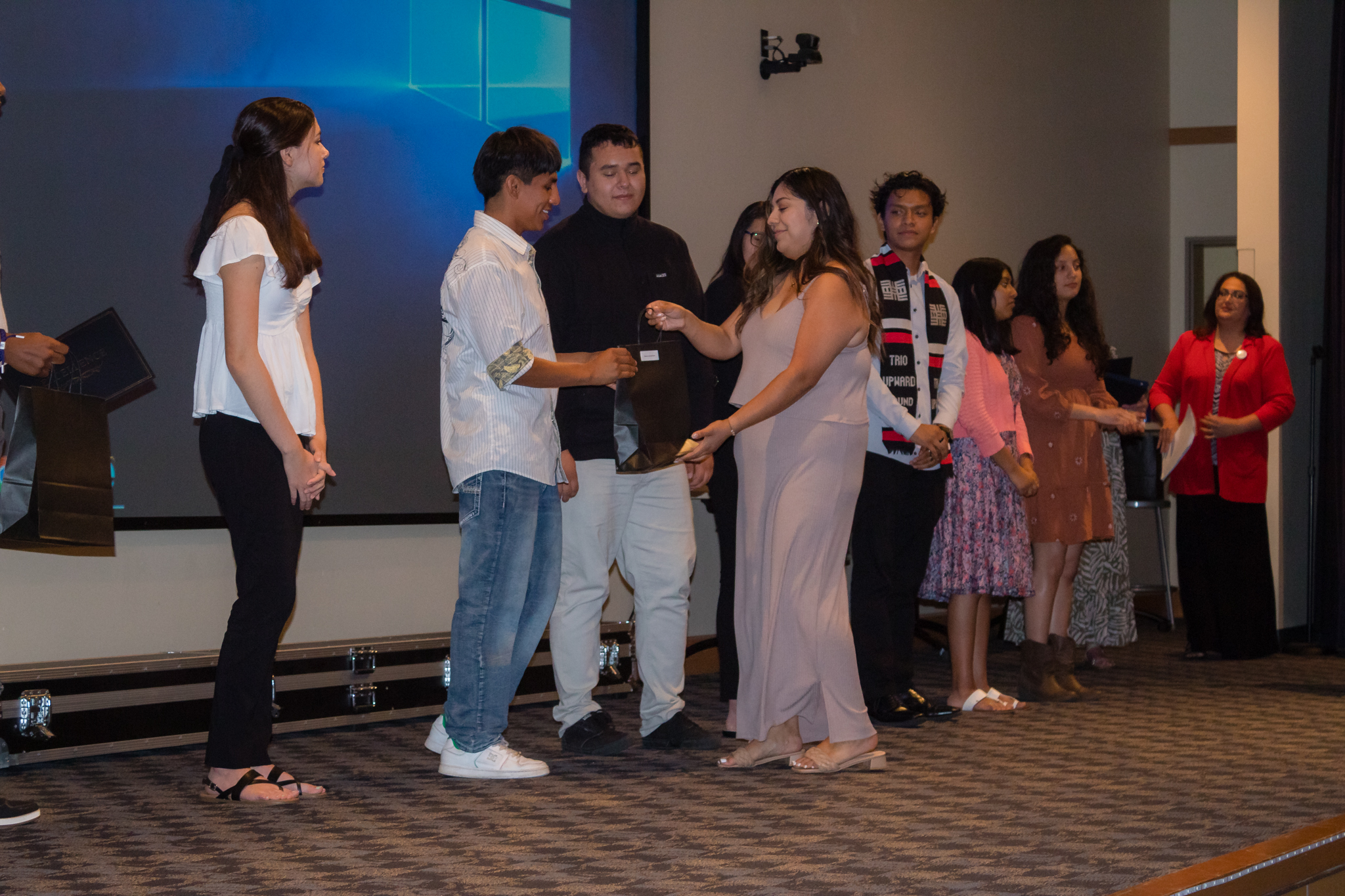 trio staff hand out awards to group of students on stage