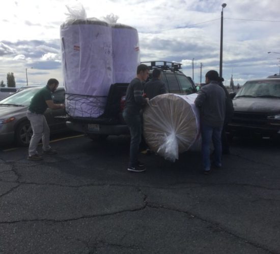 Jiu-Jitsu club members unloading mats off pickup truck