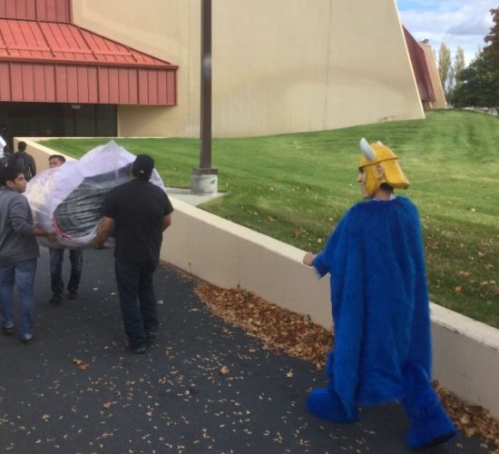 Jiu-Jitsu club members moving mats with Viking Mascot