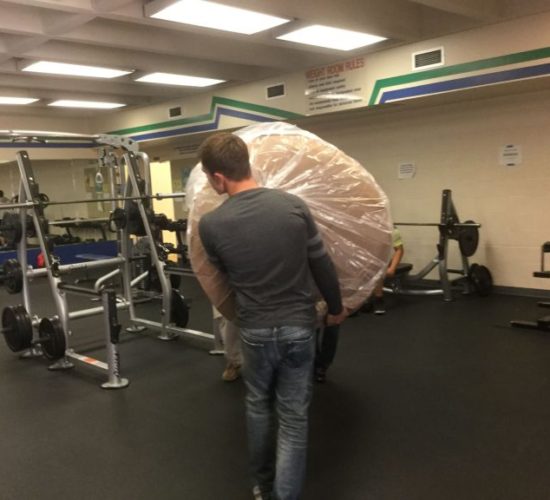 Jiu-Jitsu club members moving mats