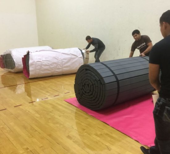 Jiu-Jitsu club members unrolling mats