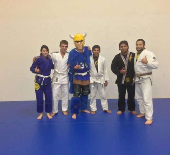 Jiu-Jitsu club members with Viking Mascot on mats