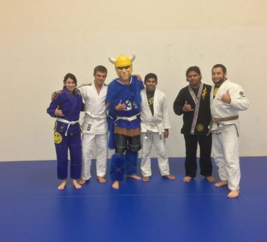 Jiu-Jitsu club members with Viking Mascot on mats