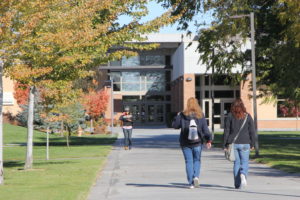 three women walking through campus