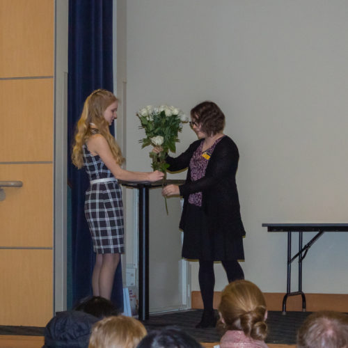 Speaker giving flowers at Phi Theta Kappa induction