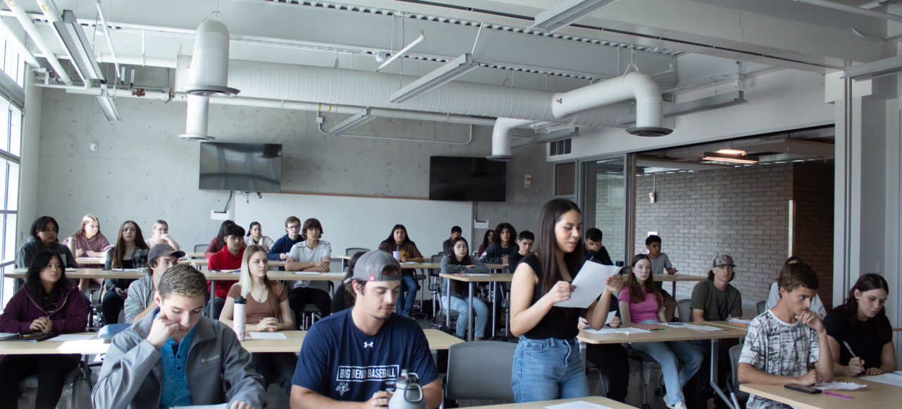 One student stands to read her argument to the rest of the class in Political Science 202.