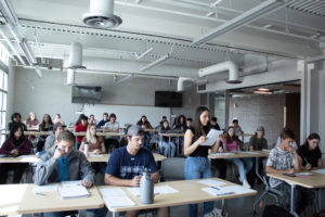 One student stands to read her argument to the rest of the class in Political Science 202.