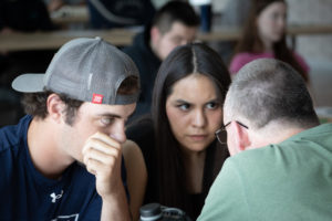Two students discuss with instructor Chris Riley.