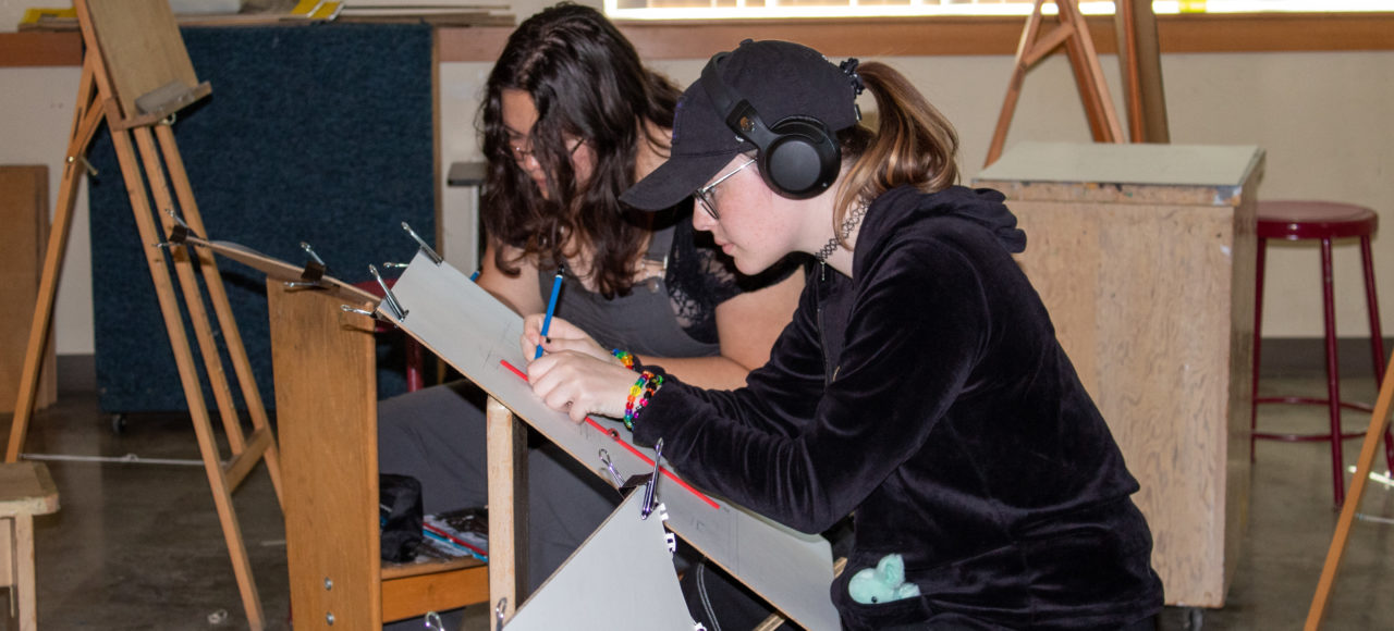 Two students working on drawing project for Art 104.