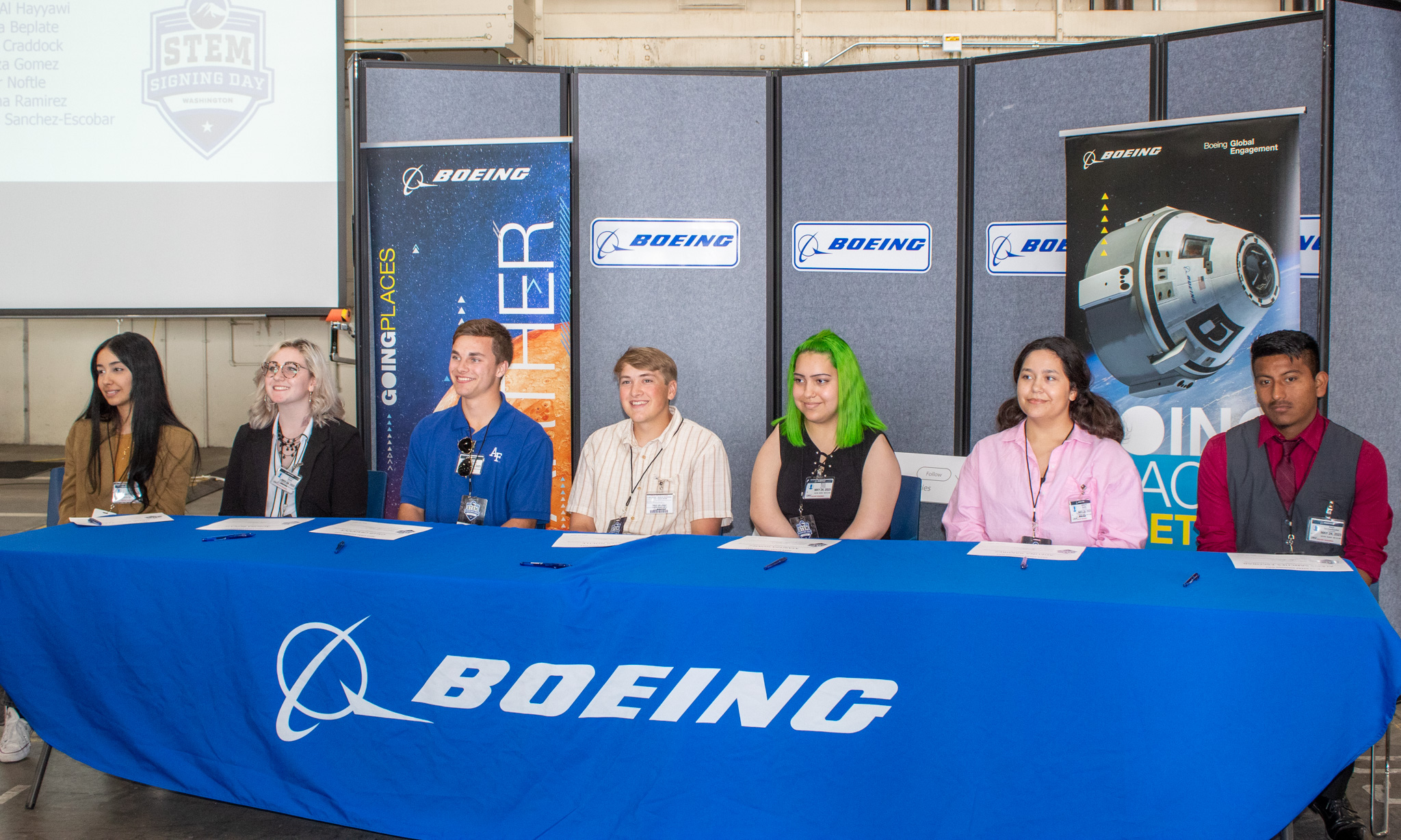 Seven students sit at a table for STEM Signing Day at Boeing.