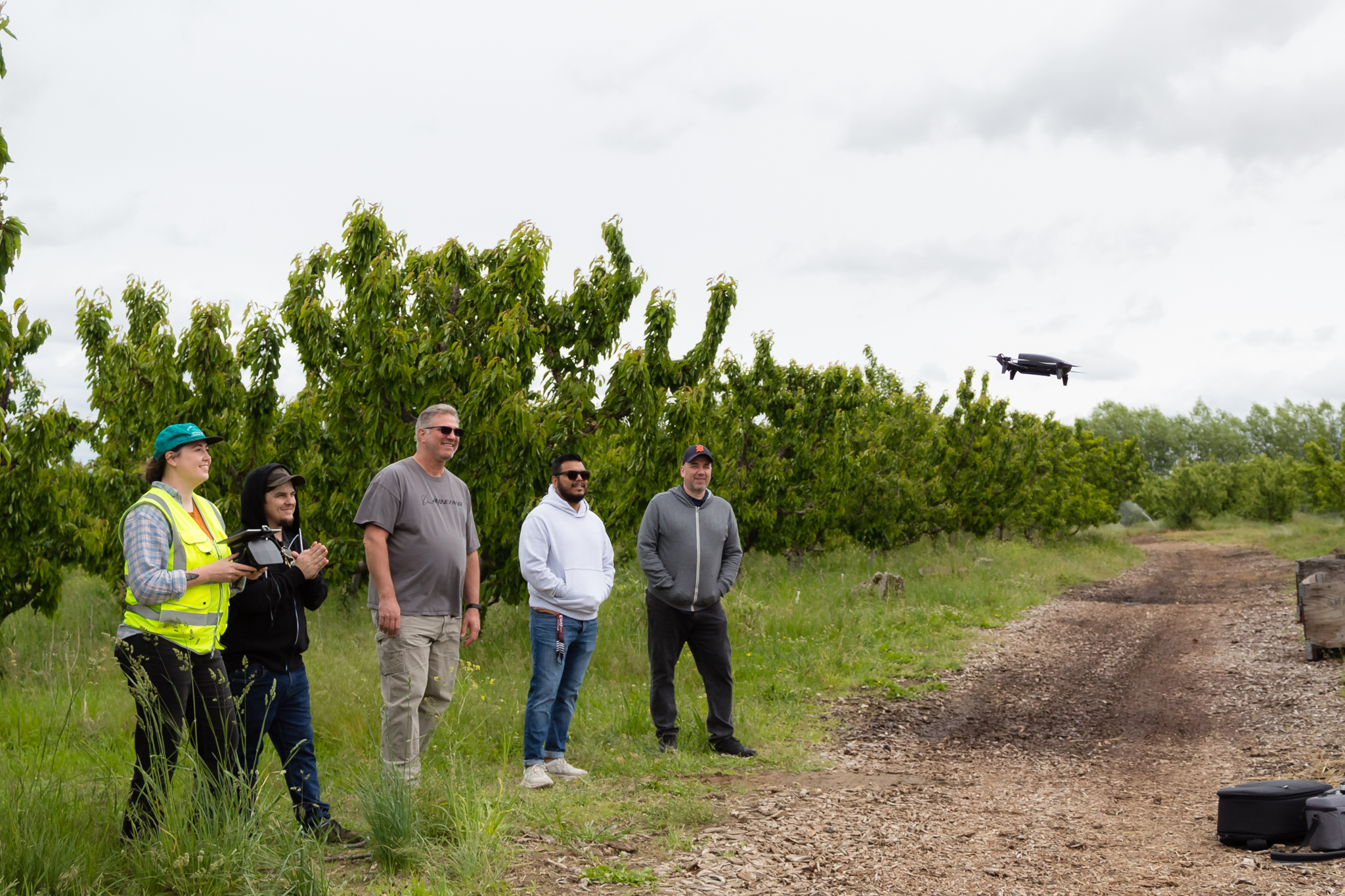 UAS instructor Kelsey Mach launches drone with students looking on