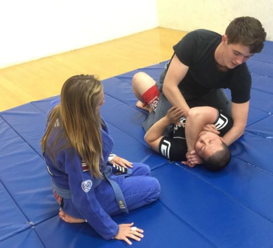 Jiu-Jitsu club members rolling on mats