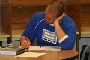 male student in blue shirt studying
