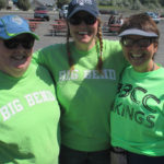 3 volunteer staff in green shirts