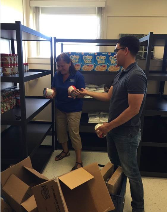 Student shelving food for the food pantry