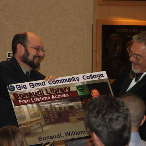 Dean of Library Tim Fuhrman presents Bill Bonaudi with an oversized library card.