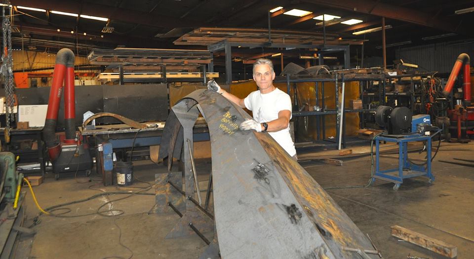 man working on metal artwork