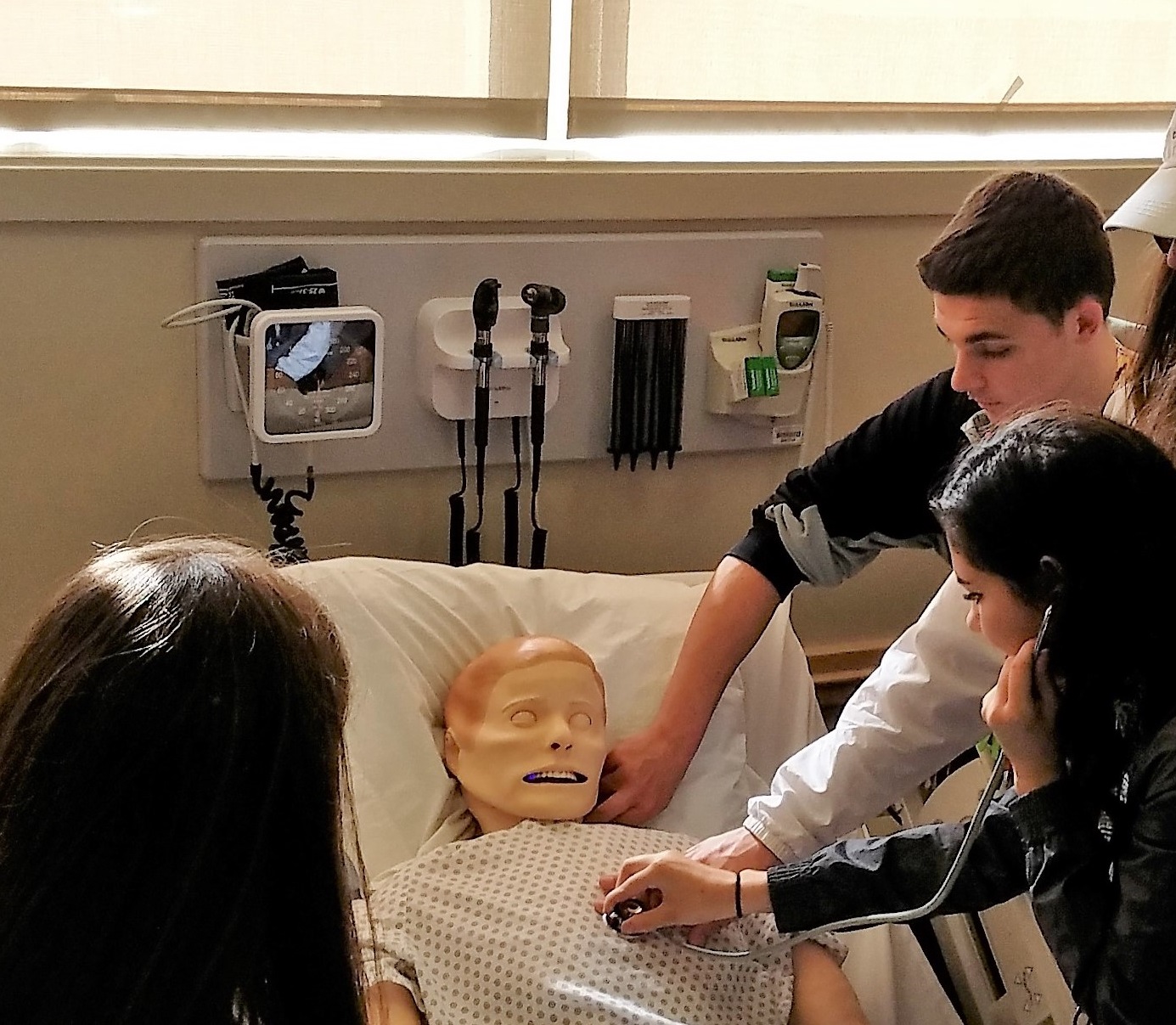 students around manikin in med sim lab