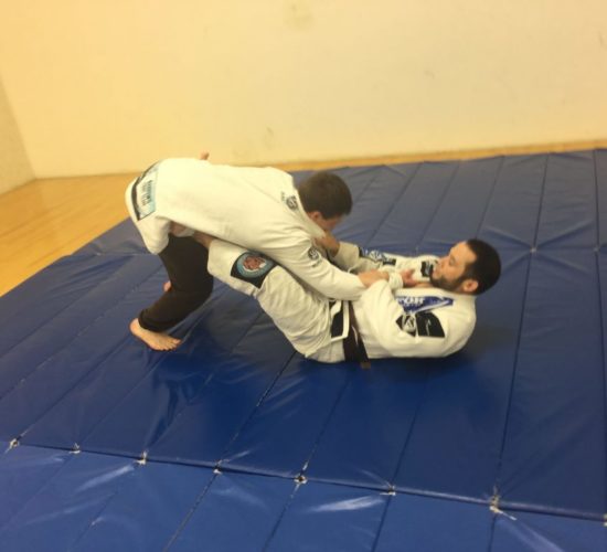 Jiu-Jitsu club members rolling on mats