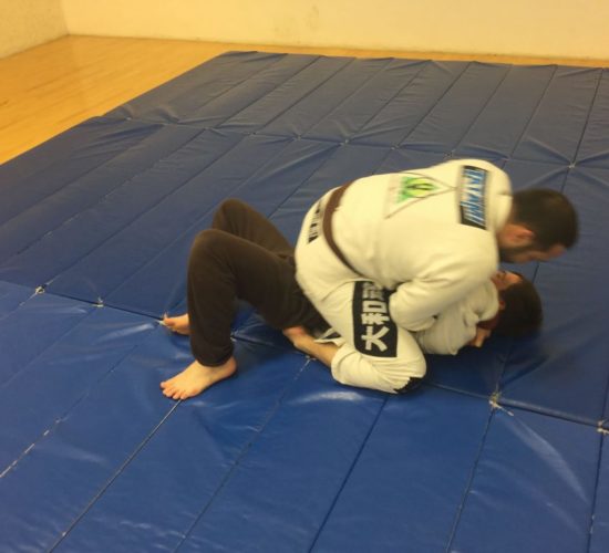 Jiu-Jitsu club members rolling on mats