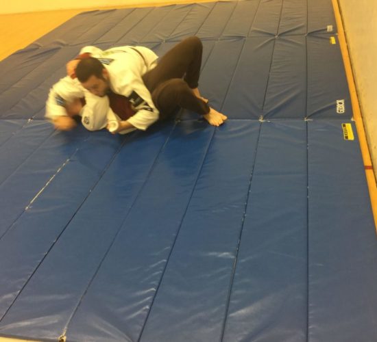 Jiu-Jitsu club members rolling on mats