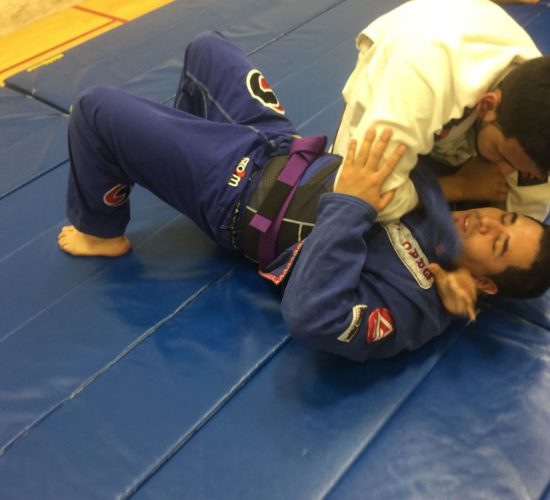 Jiu-Jitsu club members rolling on mats