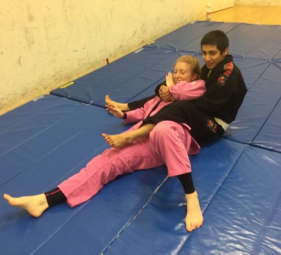 Jiu-Jitsu club members rolling on mats