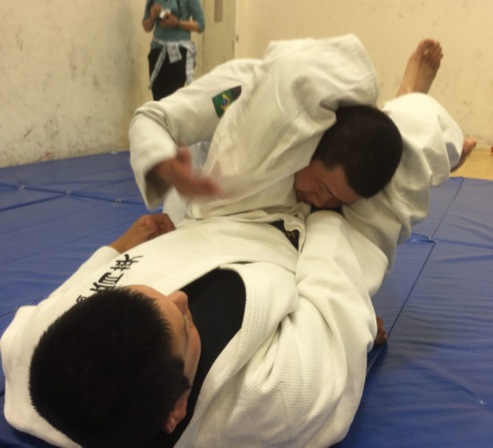 Jiu-Jitsu club members rolling on mats